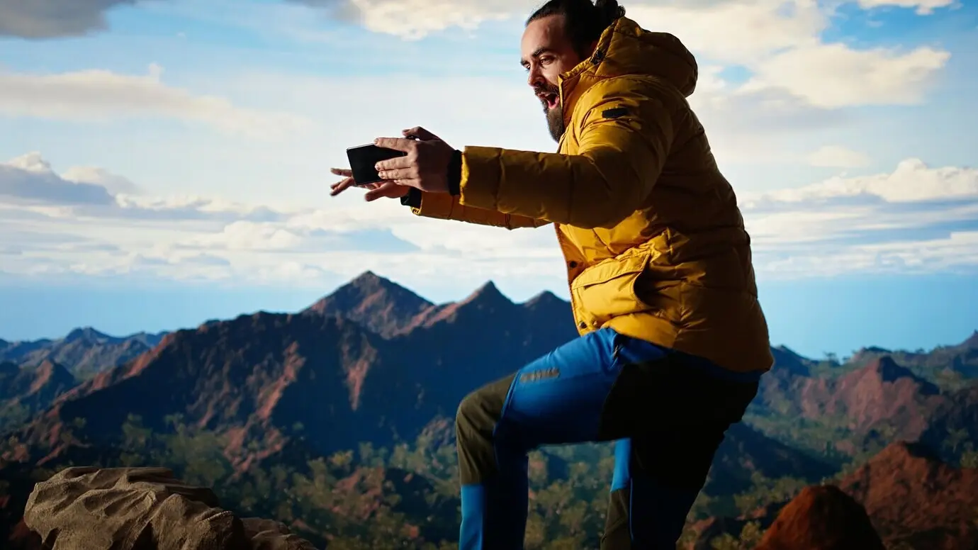 Ein leichtsinniger Abenteurer verliert beim Versuch, ein Foto zu machen, das Gleichgewicht und lässt das Handy fallen.